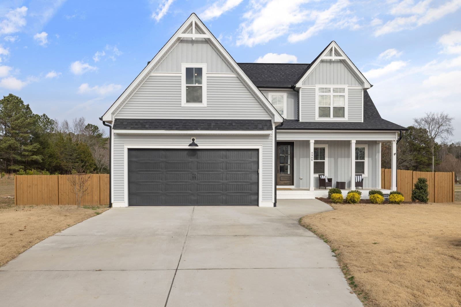 Two-story house with gray siding, white trim and a double garage